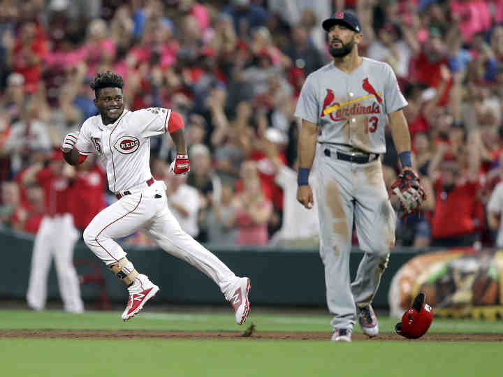 Cincinnati Reds second baseman Dilson Herrera (15) looks back toward the dugout in celebration after hitting a pinch-hit walk-off single to win the game as St. Louis Cardinals first baseman Matt Carpenter (right) walks off the field at Great American Ball Park in Cincinnati.   (Kareem Elgazzar / The Cincinnati Enquirer)